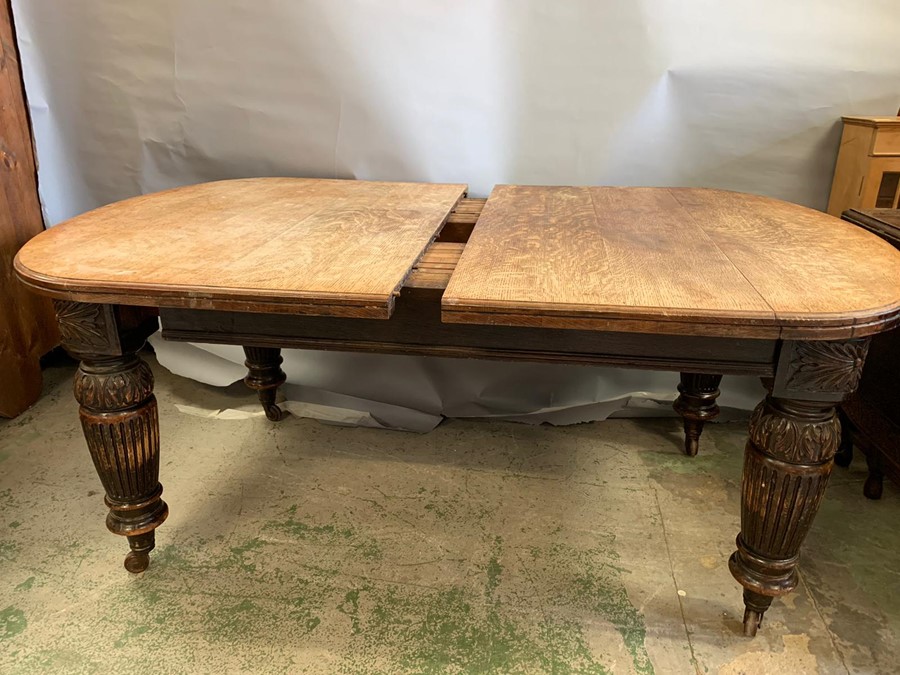 A Victorian mahogany extending dining table with turned and reeded legs ending in castors, one extra