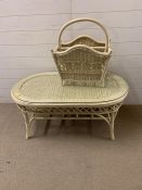 A wicker and cane oval coffee table with glass top (H47cm W100cm D53cm)