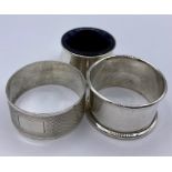 Two hallmarked silver napkin rings and a silver salt with a blue glass liner.