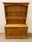 A pine Welsh dresser with plate rack and small dresser on top of a two door cupboard (H185cm