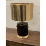 A contemporary table lamp with drum base, handles to sides and metal shade.