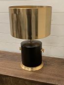 A contemporary table lamp with drum base, handles to sides and metal shade.
