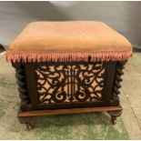 A mahogany music stool with pierced panels and barley twist pillars to corners on turned feet