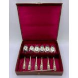A Boxed set of six decorative teaspoons and two snail picks.