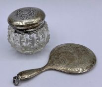 A small silver backed hand mirror and dressing table pot with hallmarked silver top.