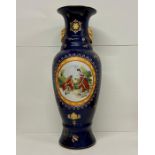 A large ornate vase on blue grounds with courting couple theme.