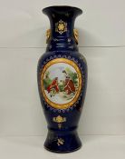 A large ornate vase on blue grounds with courting couple theme.