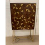 An Adamstown bar cabinet with geometric finish to front on brushed brass handles and legs by Mercury