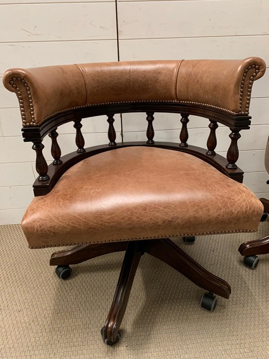 A leather captain's chairs on swivel bases with height adjustment