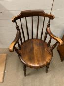 An Elm captain's chair with scroll arms and round seat