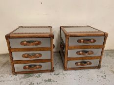 A pair of contemporary bedsides in a luggage trunk style with leather handles and metal case (