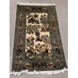 A silk rug with woodland scene and floral boarder (130cm x 80cm)