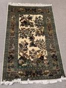 A silk rug with woodland scene and floral boarder (130cm x 80cm)