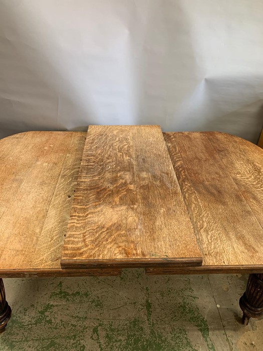 A Victorian mahogany extending dining table with turned and reeded legs ending in castors, one extra - Image 5 of 8