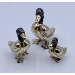 A set of three white metal ornamental ducks