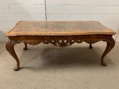 A carved yew style coffee table with glass top (H44cm W107cm D47cm)