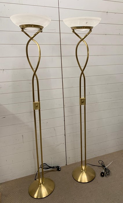 A pair of contemporary brass effect floor standing lamps with glass shades