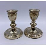 A Pair of silver squat candlesticks by A T Cannon Limited and hallmarked Birmingham 1977.