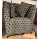 A bedroom tub chair in dotted upholstery