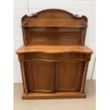 A small sideboard or serving table with barley twist pillars and cupboard to base (H136cm W103cm