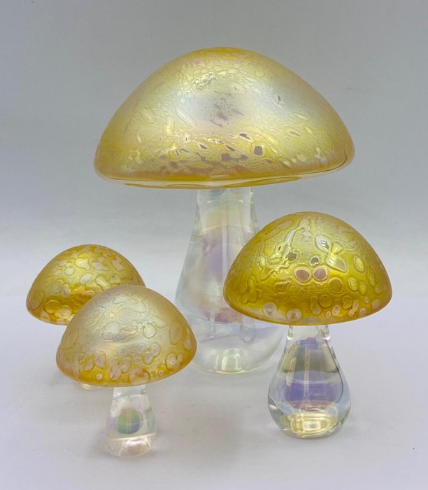 A selection of four graduated sized iridescent glass mushrooms