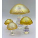 A selection of four graduated sized iridescent glass mushrooms