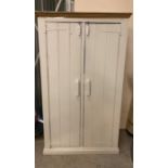 A two door wooden cupboard opening to shelves and a small hanging rail (H187cm W112cm D60cm)