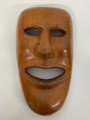 A wall hanging carved mask