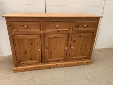 A Pine sideboard, three drawers over two cupboards. (H87cm W138cm D44cm)