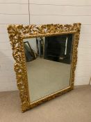 A gilt wood wall mirror with a profusely carved frame AF (130cm x 107cm)