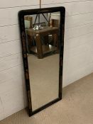 An ebonised inlay wall mirror