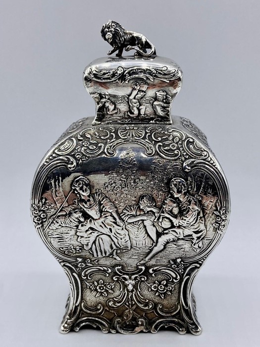 A silver tea caddy with repousse design and lion finial by Samuel Boyce, hallmarked for Chester 1903