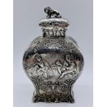 A silver tea caddy with repousse design and lion finial by Samuel Boyce, hallmarked for Chester 1903