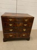 An Early 18th Century walnut chest of drawers of small proportions, having quarter veneered top with