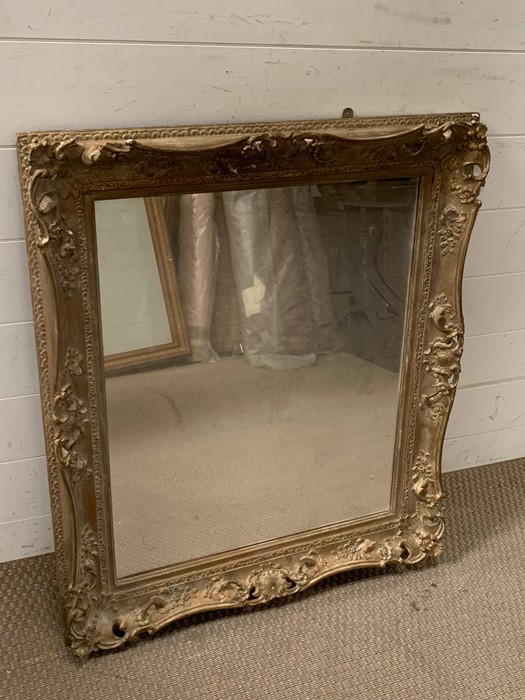 A giltwood wall mirror in a J.J.Patrickson gilded frame, Fulham Road London