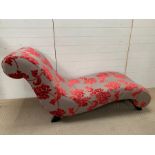 A chaise/day bed with grey and pink upholstery