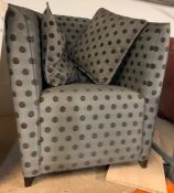 A bedroom tub chair in dotted upholstery