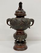 A Chinese urn or censor with Foo dog finial.