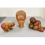 Three carved wooden figures, one bust of a women, one sleeping baby and one of a figure praying