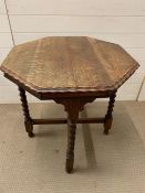 An oak side table with barley twist legs and cross stretchers and pie crust edge