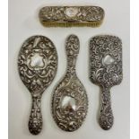 A selection of three silver backed vanity mirrors and one brush, various designs and hallmarks.