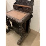 An Anglo-Indian carved Davenport. Writing surface with enclosing drawers, flanked each side with