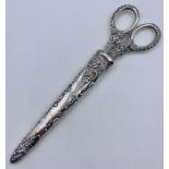 A set of silver handled scissors in a silver holder by Levi & Salaman