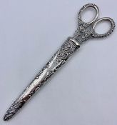 A set of silver handled scissors in a silver holder by Levi & Salaman