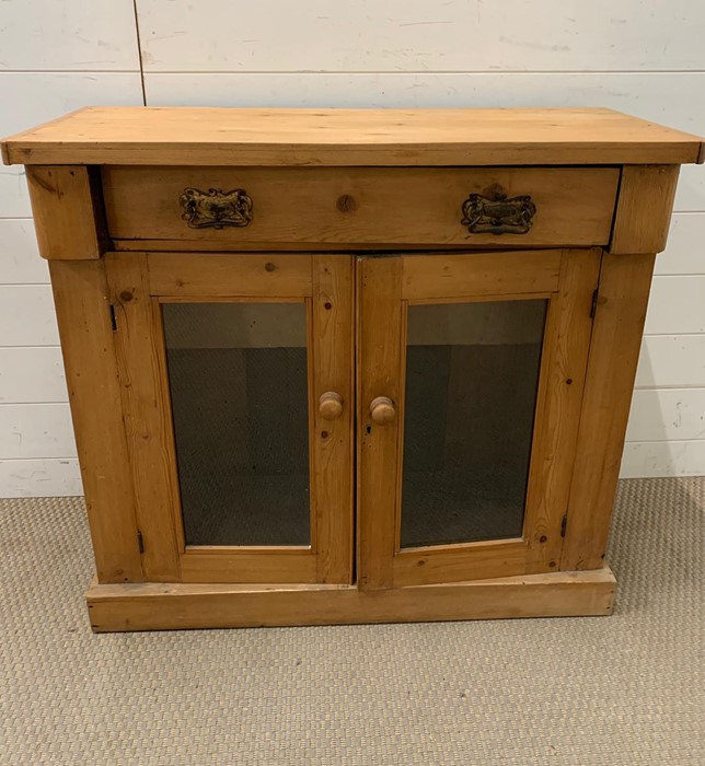 A pine side cupboard with glazed double doors (H82cm W89cm D37cm)