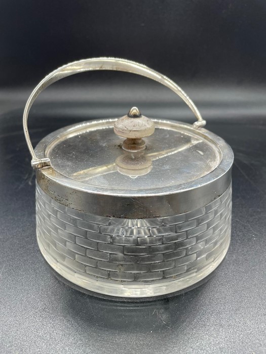 A Silver lidded and handles glass biscuit barrel.