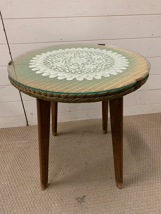 A Lloyd Loom side table on teak legs and glass top (H61cm Dia56cm)