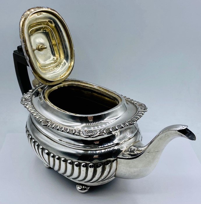 A substantial silver teapot, (Total weight 695g) on four feet, by George Nathan & Ridley Hayes and