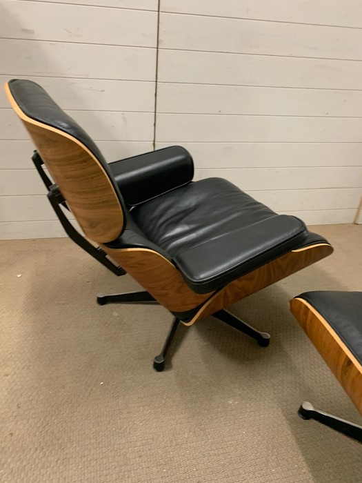 A rosewood lounge chair and ottoman. After Charles and Roy Eames for Herman Milner with black - Image 4 of 9