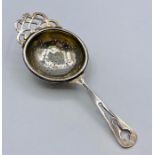 A silver tea strainer, hallmarked Birmingham 1949 by Williams Suckling Ltd (14.5cm long)